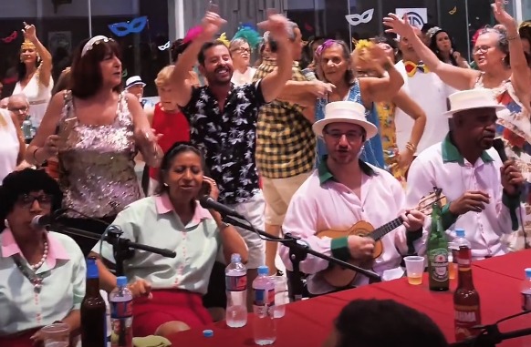 Público vibrando em show de samba